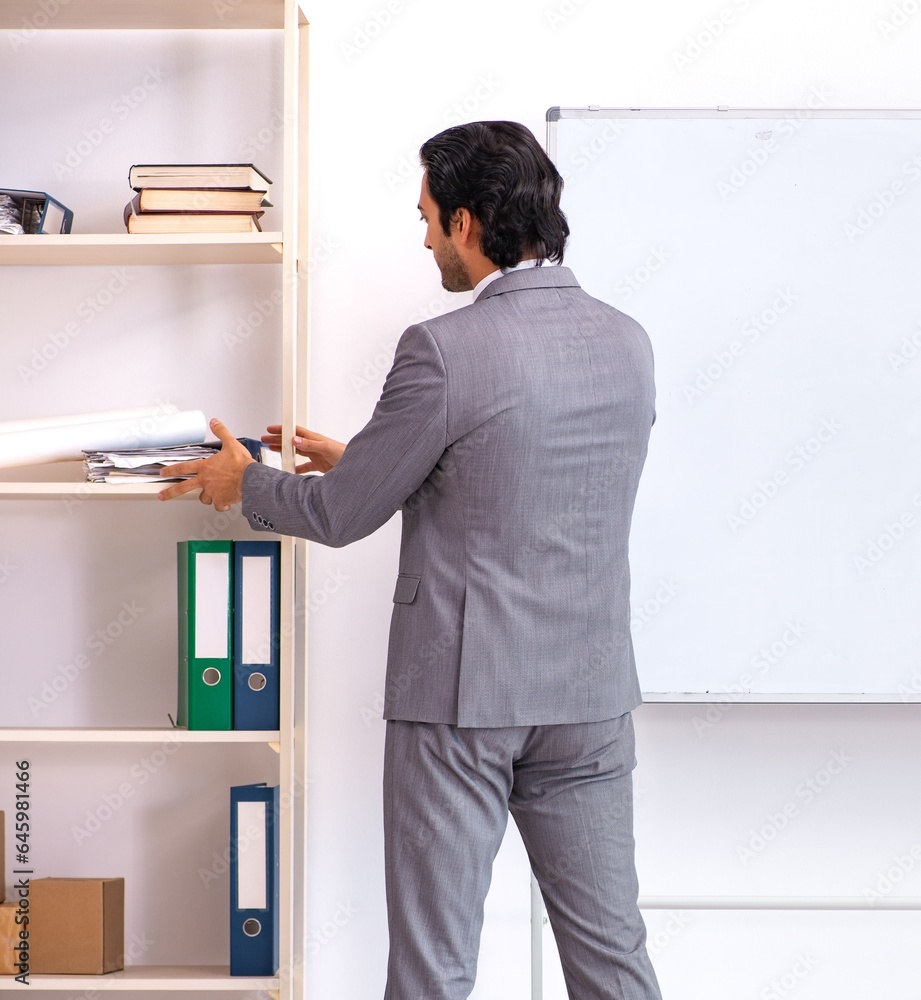 Young handsome businessman standing in front of whiteboard