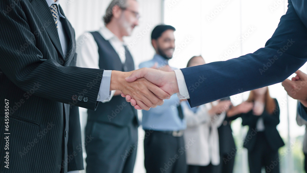 Close up shaking hands of business people close deal making agreement after successful meeting. Business partners shake hands. Business workers clapping hands on background. Partnership concept