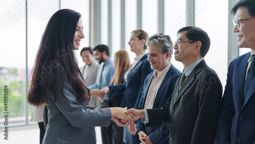 Successful business team shaking hands together after success business meeting at office. Happy business people shaking hands together. Business success concept