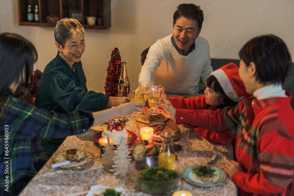 クリスマスホームパーティーで乾杯する日本人家族 クリスマスホームパーティーで乾杯する日本人家族