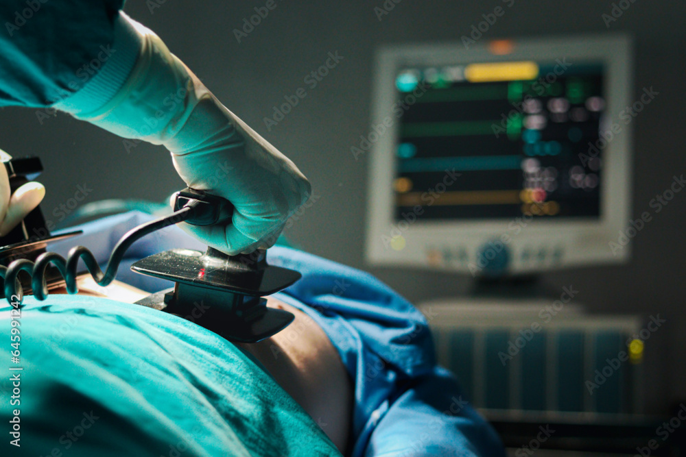 Surgeon doctor hand hold defibrillator to pump chest heart patient to save life sick people in operating room at hospital, surgical team using equipment to do surgery. healthcare and medical concept. - obrazy, fototapety, plakaty 
