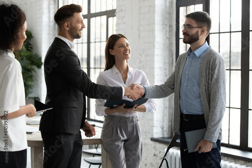 Happy male business partners shake hands get acquainted greeting in office, smiling businessmen handshake close deal or make agreement after successful negotiation, partnership concept