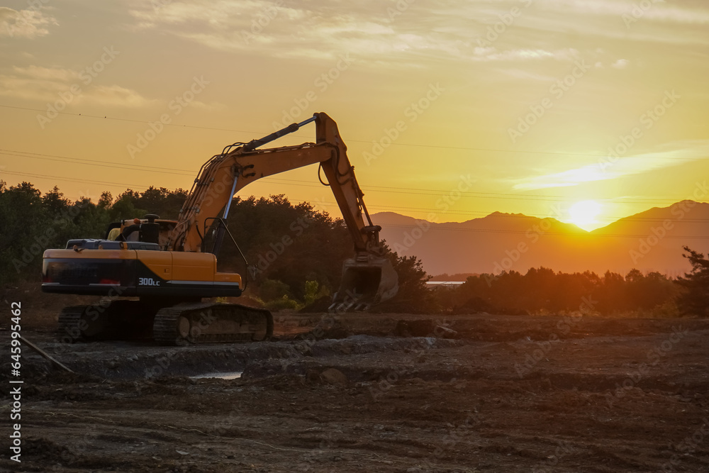 excavator in construction site on sunset sky background excavator in construction site on sunset sky background