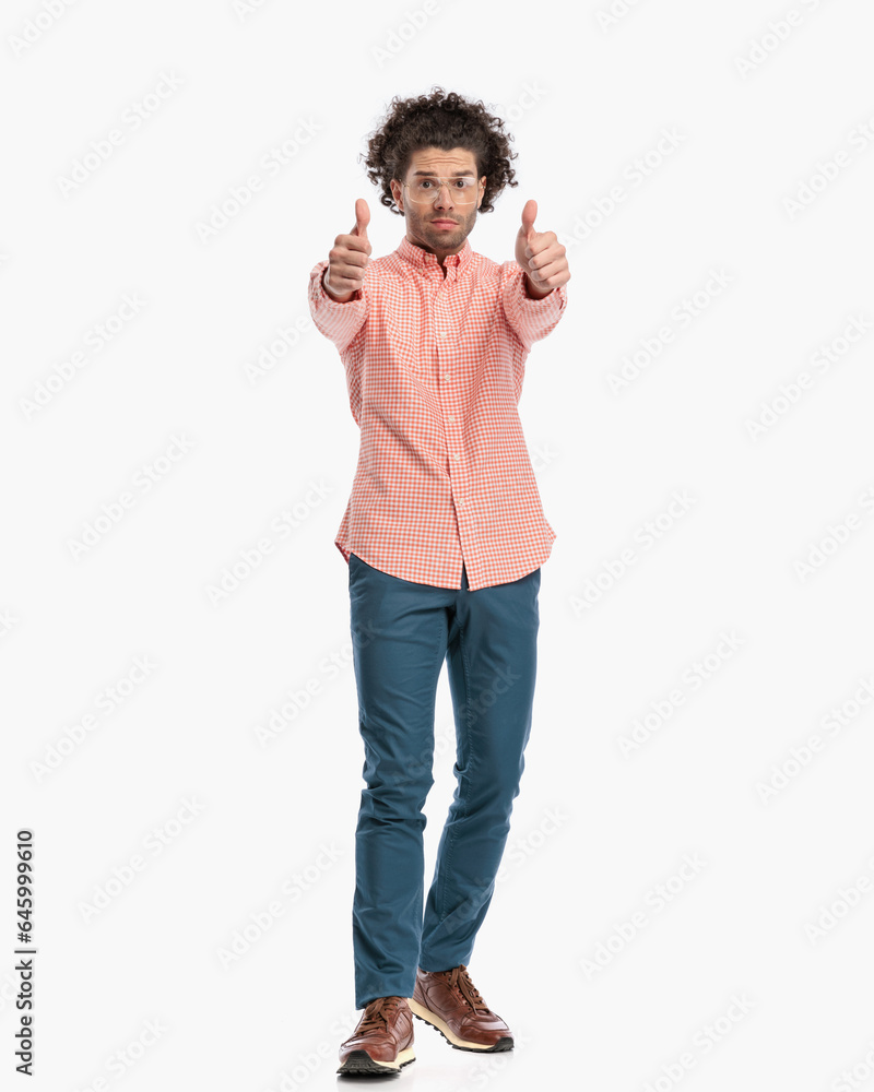 attractive fashion man with curly hair making thumbs up gesture attractive fashion man with curly hair making thumbs up gesture