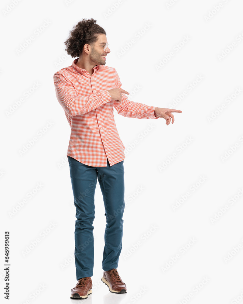 handsome curly hair guy with glasses looking and pointing fingers to side handsome curly hair guy with glasses looking and pointing fingers to side