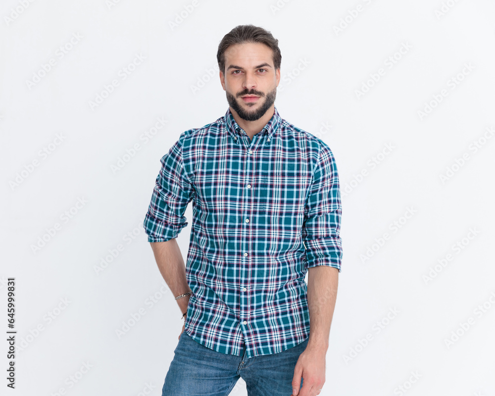 sexy unshaved man wearing casual plaid shirt holding hands in pockets sexy unshaved man wearing casual plaid shirt holding hands in pockets