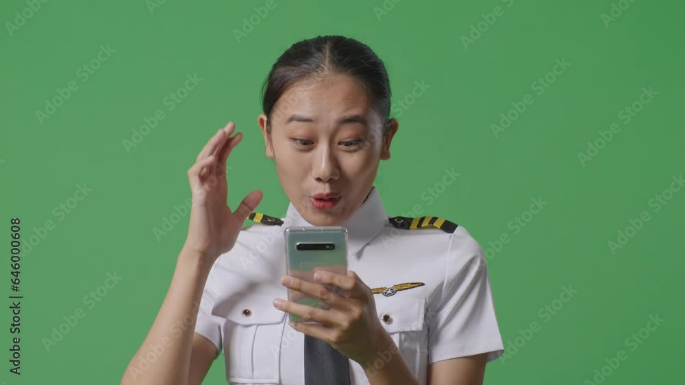 Close Up Of Asian Woman Pilot Looking At Smartphone, Smiling, And Saying Wow While Standing In The Green Screen Background Studio
Close Up Of Asian Woman Pilot Looking At Smartphone, Smiling, And Saying Wow While Standing In The Green Screen Background Studio