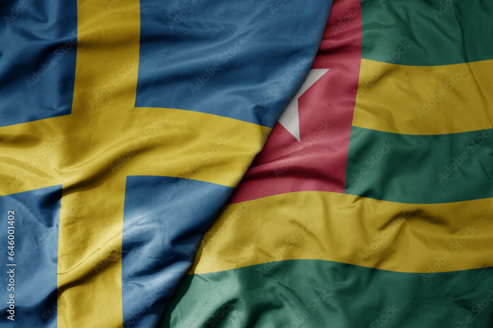 Obraz premium big waving national colorful flag of sweden and national flag of togo .