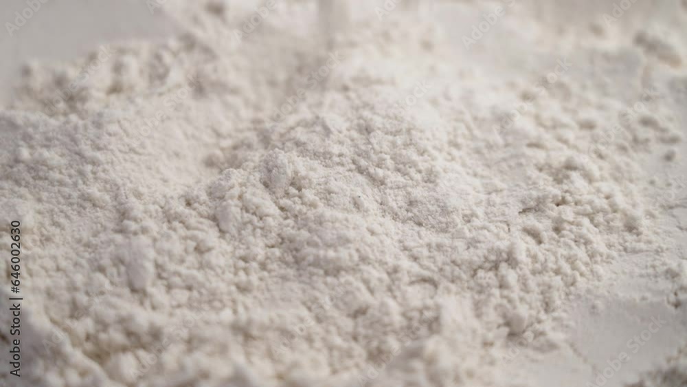 White rice flour particles falling in slow motion. Dietary gluten free bakery ingredient. Rotation White rice flour particles falling in slow motion. Dietary gluten free bakery ingredient. Rotation