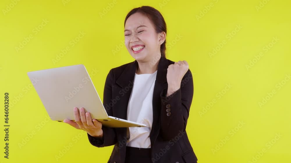 Portrait young asian business woman work on laptop computer to internet online and success on yellow background, businesswoman in suit glad and using notebook, marketing and communication.