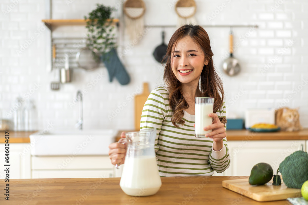 Portrait of beauty healthy asian woman smiling and having protein breakfast drinking and hold glasses of milk of fresh milk, nutrition,calcium and vitamin,dairy product in kitchen at home.Diet concept Portrait of beauty healthy asian woman smiling and having protein breakfast drinking and hold glasses of milk of fresh milk, nutrition,calcium and vitamin,dairy product in kitchen at home.Diet concept