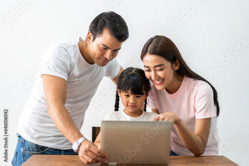 Mother and father with asian kid girl learn and look at laptop computer reviewing lesson study with online education e-learning.student look educational knowledge in homeschool at home.Education