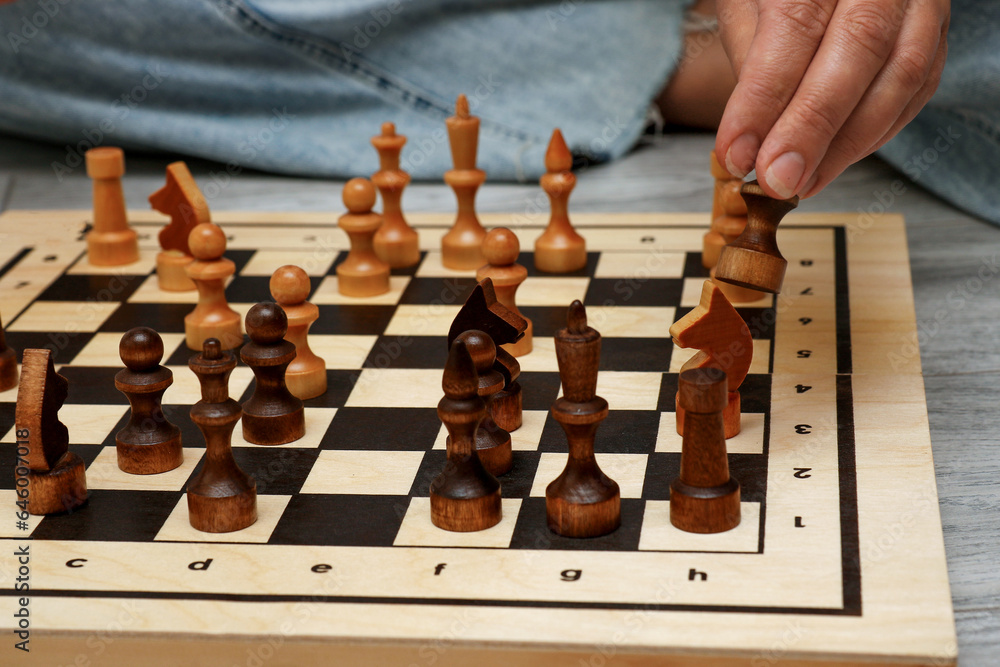 female hand rearranging pieces on a chessboard female hand rearranging pieces on a chessboard