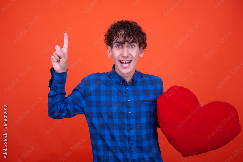 Funny curly guy posing in the studio on an orange background. Funny curly guy posing in the studio on an orange background.