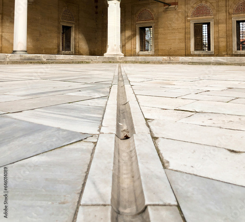In terms of perspective, the stone arched domed mosque in the marble courtyard, shot from the ground and in focus, offers an aesthetic and historical view.