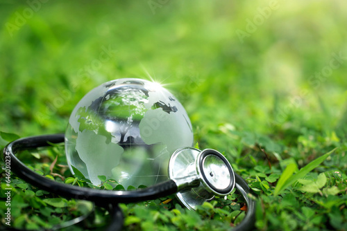 Environment Earth Day Concept.Crystal Earth with a medical doctor\'s stethoscope on green.Saving environment, and environmentally sustainable. Save Earth. Global healthcare and Green Earth Day. ESG