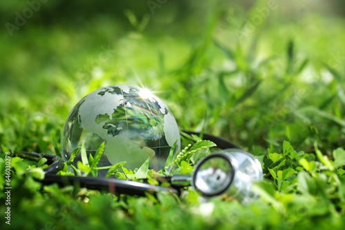 Environment Earth Day Concept.Crystal Earth with a medical doctor\'s stethoscope on green.Saving environment, and environmentally sustainable. Save Earth. Global healthcare and Green Earth Day. ESG
