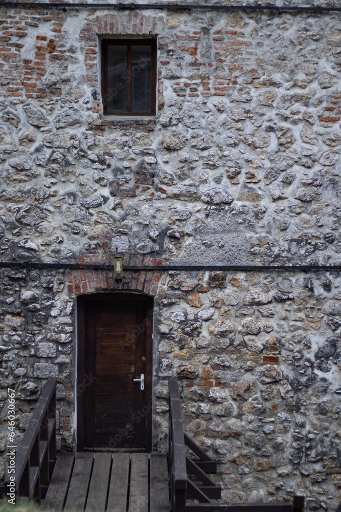 Building in medieval style with an entrance through an old door. Old wooden bridge Building in medieval style with an entrance through an old door. Old wooden bridge