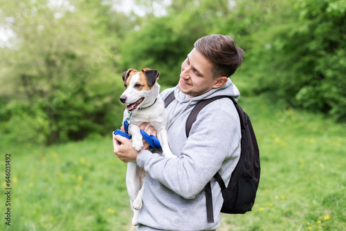 A happy man hugs his dog. Jack Russell Terrier walking with owner in park. Pet, domestic animal. Parson Russell Terrier with dog handler on training. 