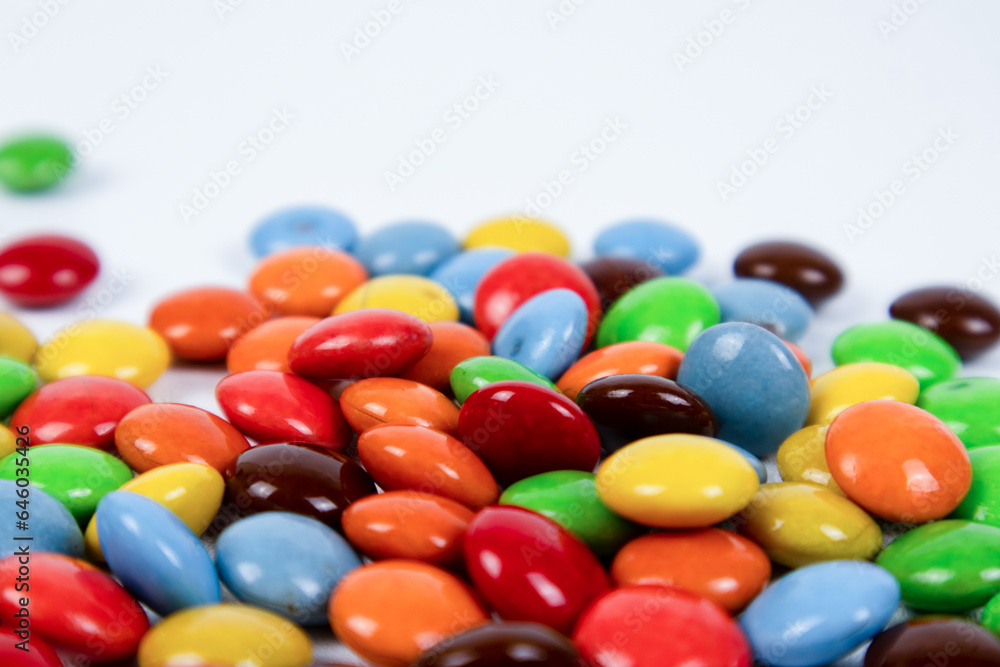 pile of colorful chocolate candies on white background pile of colorful chocolate candies on white background