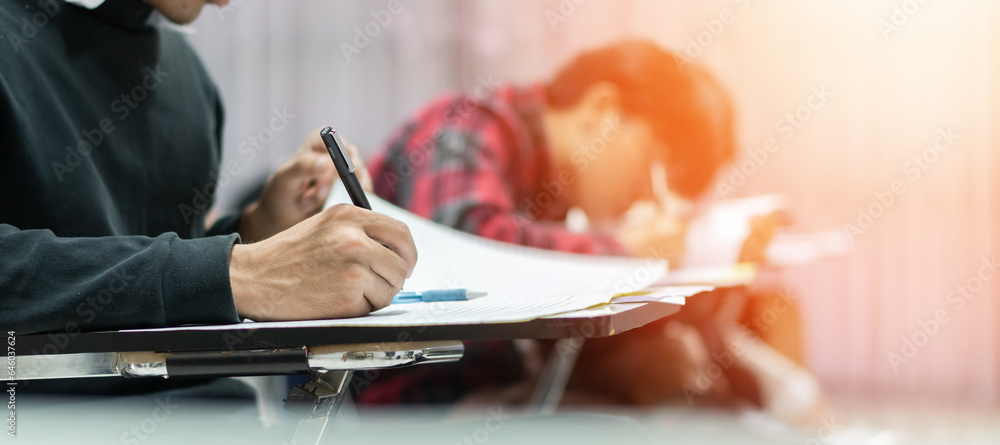 Exam at school with student's taking educational admission test in class, thinking hard, writing answer in university classroom, education and world literacy day concept - obrazy, fototapety, plakaty 