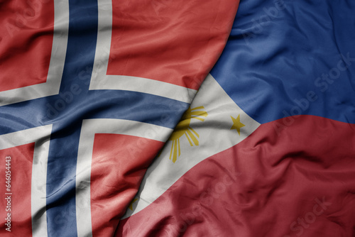 big waving national colorful flag of norway and national flag of philippines .