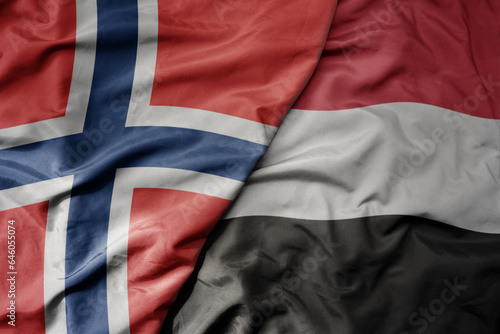 big waving national colorful flag of norway and national flag of yemen .