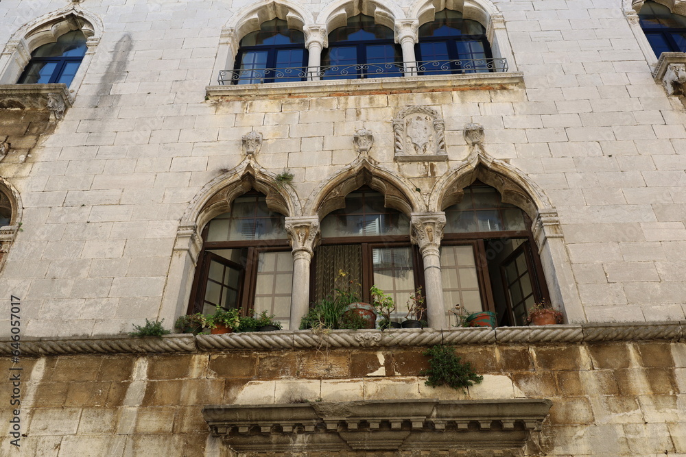 View of traditional colorful croatian windows with flower pots in the windows, in the old town of Porec, Croatia. 