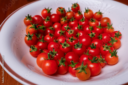 Many small red cherry tomatoes in a plate