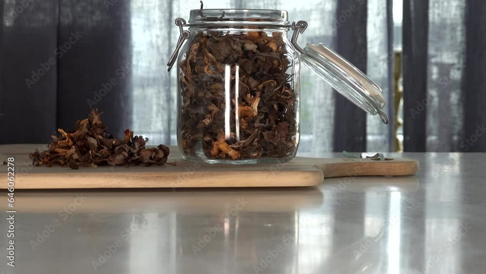 Stockholm, Sweden A man places wilderness-picked, foraged, and dried chanterelle mushrooms into a jar on a table. Stockholm, Sweden A man places wilderness-picked, foraged, and dried chanterelle mushrooms into a jar on a table.