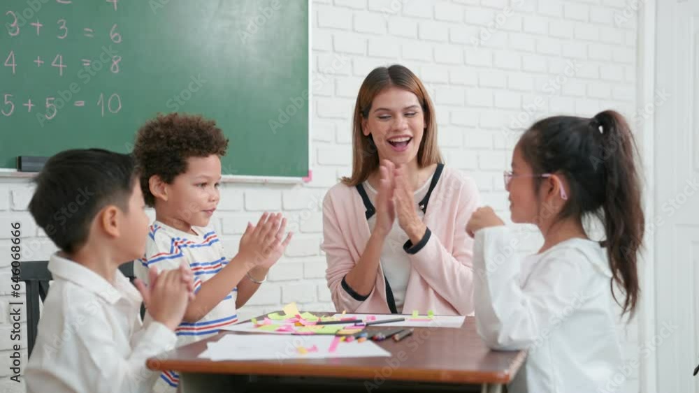 Students of different nationalities learning together in a classroom. Young female caucasian teacher working with little children group in class explaining. Back to kindergarten school. Students of different nationalities learning together in a classroom. Young female caucasian teacher working with little children group in class explaining. Back to kindergarten school.