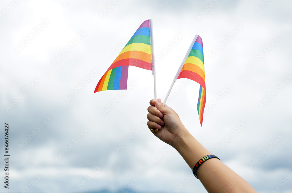 LGBT flag on sky background, it is a symbol of lesbian, gay, bisexual, and transgender (LGBT) pride and LGBT social movements. Also known as the gay pride flag or LGBT. LGBT flag on sky background, it is a symbol of lesbian, gay, bisexual, and transgender (LGBT) pride and LGBT social movements. Also known as the gay pride flag or LGBT.