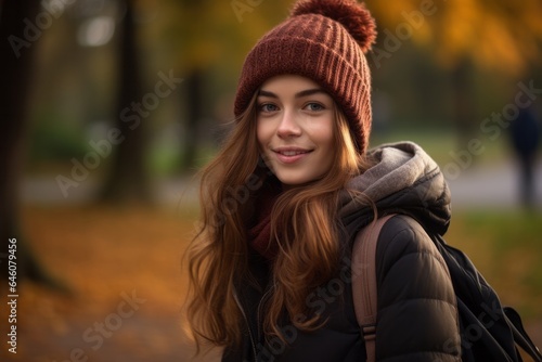 young caucasic woman with a whoolen hat girl walking in the park in autumn