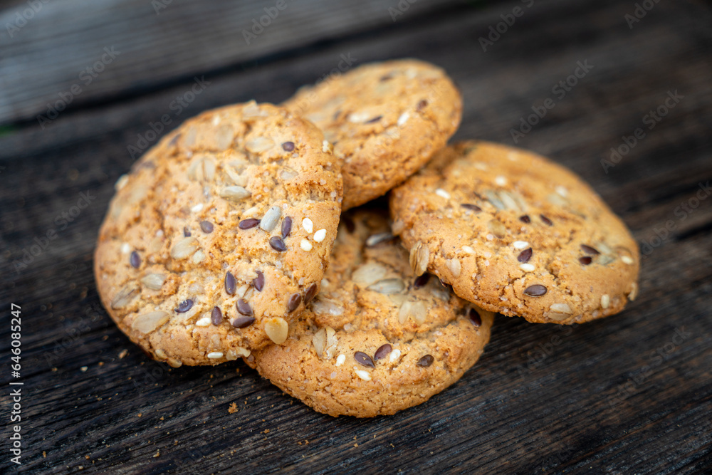 oatmeal thin round cookies with lots of sesame seeds, delicious cookies with white sesame seeds on a wooden table and wooden kitchen appliances. oatmeal cookies with seeds on a wooden table oatmeal thin round cookies with lots of sesame seeds, delicious cookies with white sesame seeds on a wooden table and wooden kitchen appliances. oatmeal cookies with seeds on a wooden table