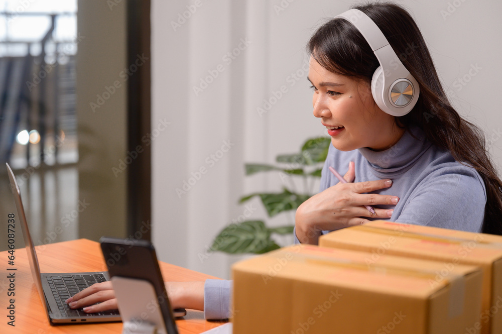 Asian woman selling online using her laptop and working at home You are a small business owner or small business entrepreneur who delivers online marketing packaging boxes. Asian woman selling online using her laptop and working at home You are a small business owner or small business entrepreneur who delivers online marketing packaging boxes.