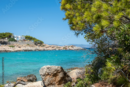 Greece Agistri island destination Aponisos beach. Rocky beach pine tree clear turquoise sea water.
