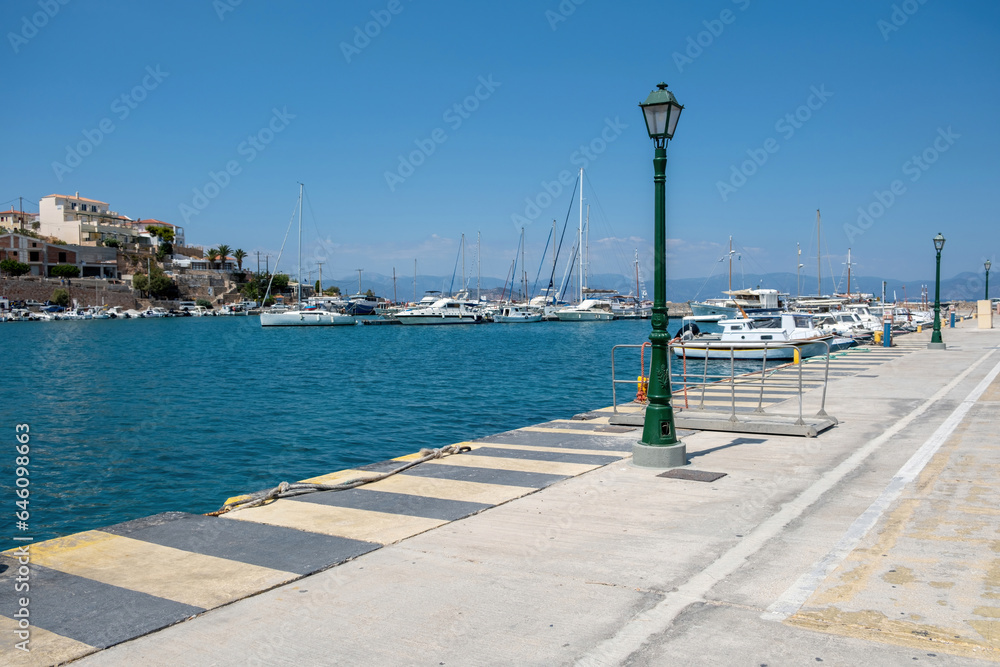 Obraz premium Megalochori, Milos, Miloi port Agistri island Greece. Harbor with bollard and moored yacht, sea sky