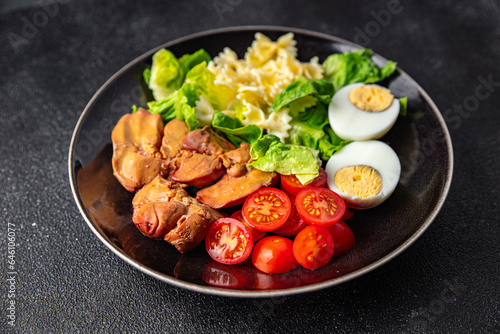 salad chicken liver, pasta salad , tomato, green leaf lettuce, boiled egg, farfalle snack meal food on the table copy space food background rustic top view