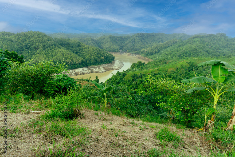 During the rainy season, the dense green hills blend into the blue sky. Sangu river flows below. Hilly region of Bandarban district of Bangladesh.