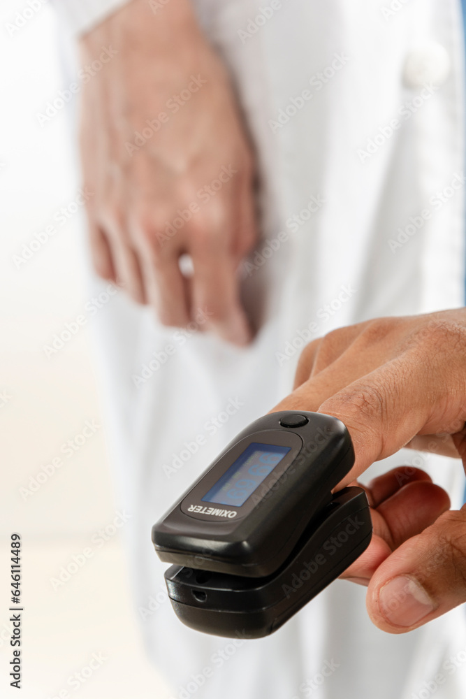 Man using a pulse oximeter in a finger Man using a pulse oximeter in a finger