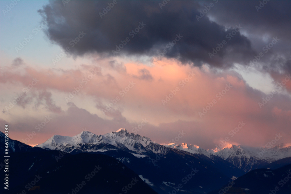 Picturesque sunset over picturesque winter mountains with clouds