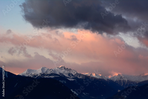 Picturesque sunset over picturesque winter mountains with clouds