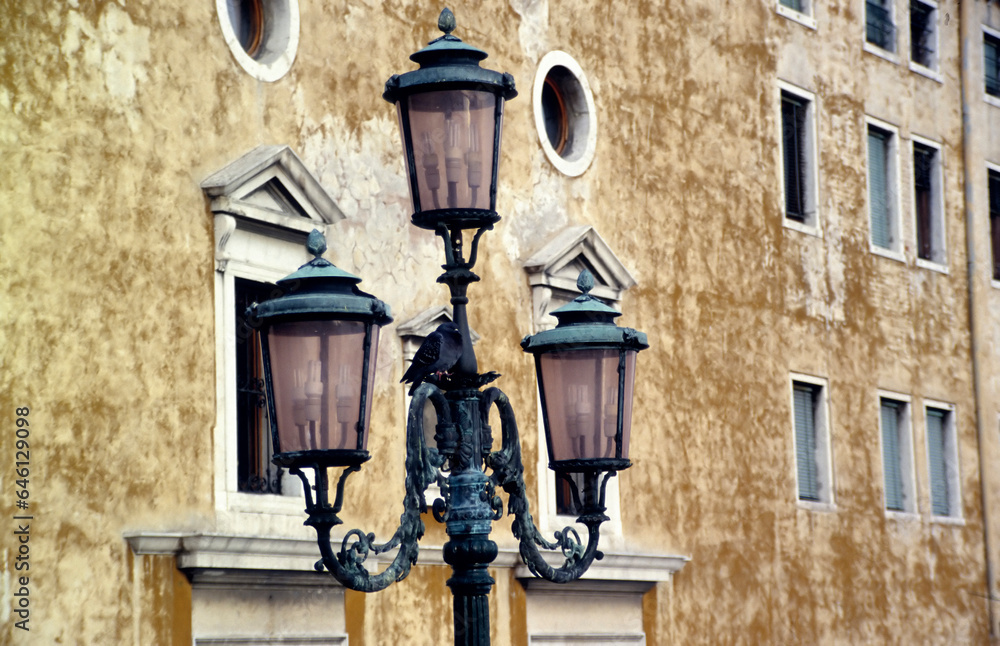 A traditional architectural street lantern against the background of a housae in Venice, Italy 