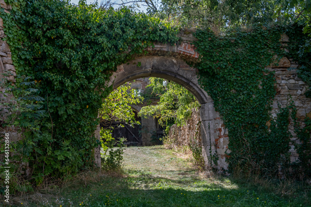 Stone arch in ancient wall, passageway through courtyard, ancient european architecture.