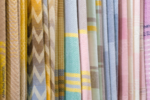 Mix colorful hanging vertical stripe textile, fabrics, cloths on the rack. Texture of multicolored fabrics close up. © Aleksandr Matveev