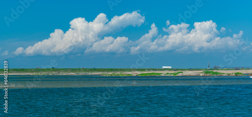 White fluffy clouds against a blue sky  lake in the foreground  Ukraine