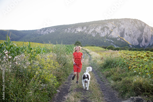 woman in red dress with white dog in nature