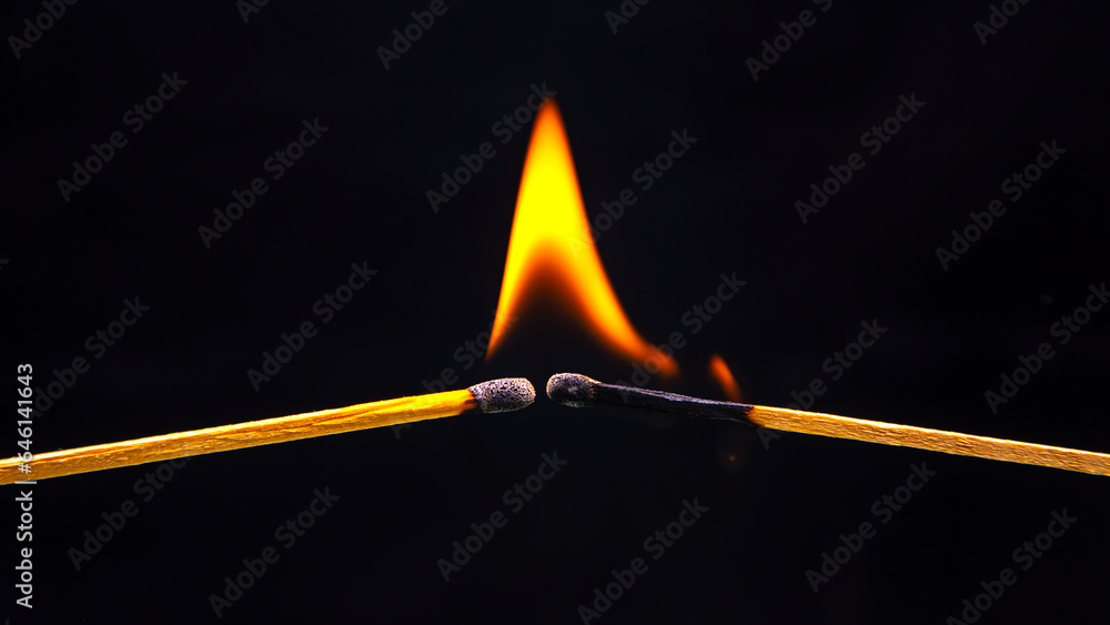 Burning match on a black background. Heat and light from fire flame