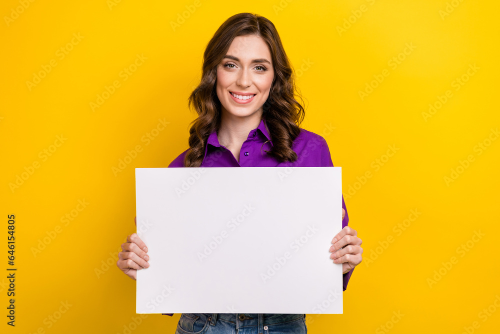 Portrait of pretty cheerful lady toothy smile arms hold empty space ad blank isolated on yellow color background Portrait of pretty cheerful lady toothy smile arms hold empty space ad blank isolated on yellow color background