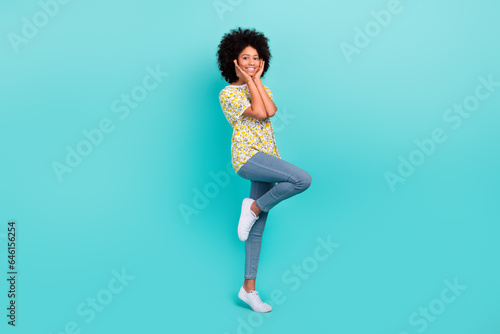 Full length photo of lovely girl wear trendy denim clothes hands touch face cheeks enjoy walk good mood isolated on cyan color background